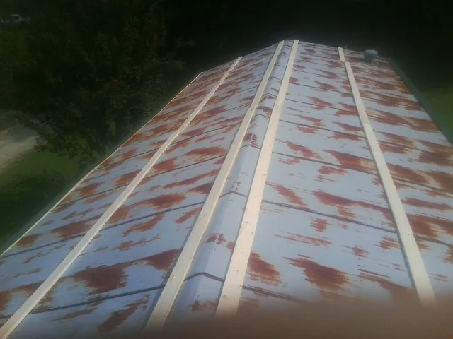 Rusted metal roof panels with new wood purlins before replacement — Storm Damage Roof Repair in Medon by Roofing Brothers