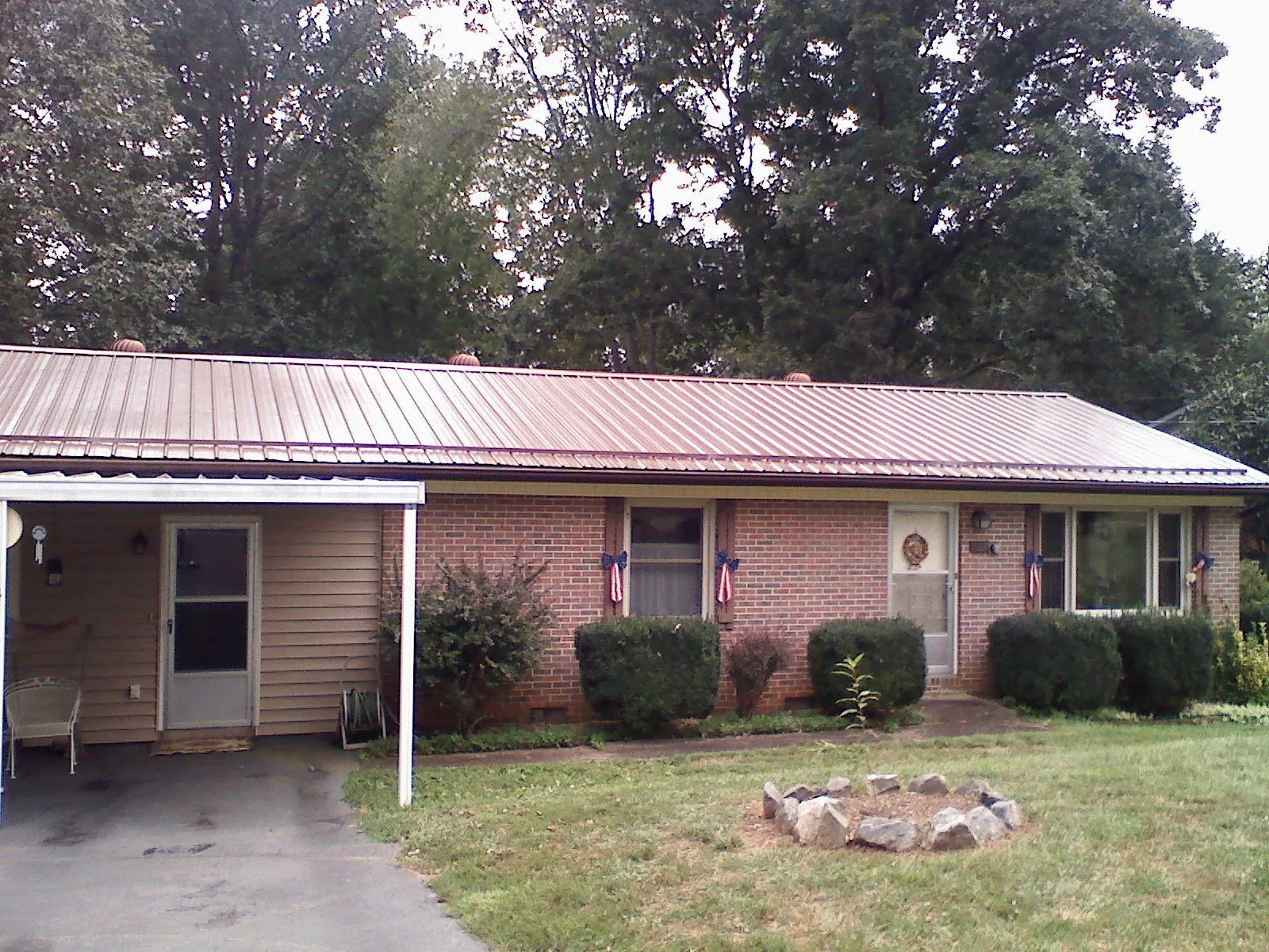 Bronze metal roof and carport on a brick ranch home — Roof Repair work by our crew in Medon